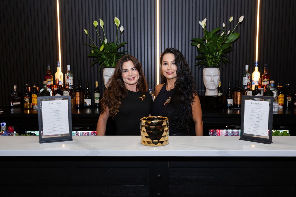 Two bartenders behind the black bar at Trellis 925